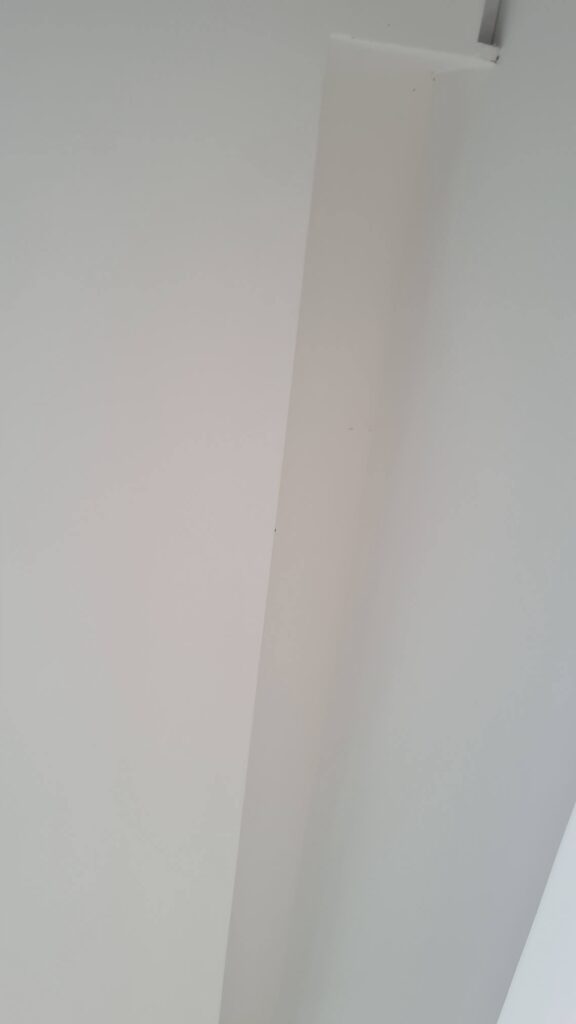 Encontro entre parede e forro em vistoria de imóvel novo.