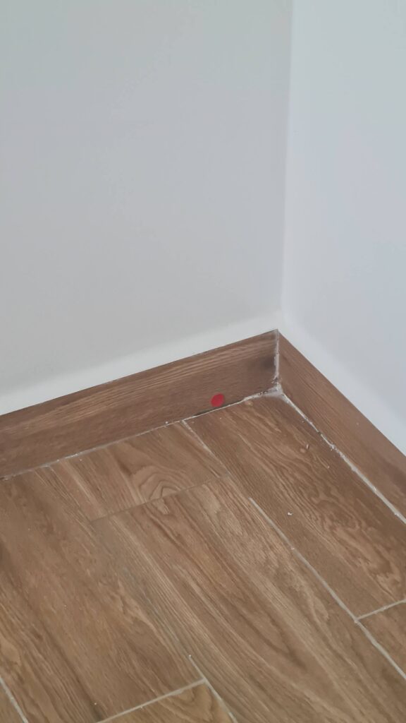 Rodapé e encontro entre piso e parede em vistoria de imóvel novo.
